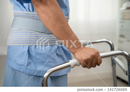 Asian senior pain back wearing elastic support belt with walker. Asian senior pain back wearing elastic support belt with walker. 142726089