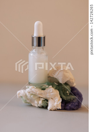 A close-up of a white glass bottle with a dropper with a moisturizing serum with bubbles A close-up of a white glass bottle with a dropper with a moisturizing serum with bubbles 142726265