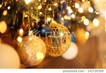Close-up of gold and silver balls on the Christmas tree. Beautiful bokeh effect with lights Close-up of gold and silver balls on the Christmas tree. Beautiful bokeh effect with lights 142726309