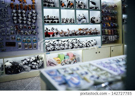 Display of assorted panda-themed merchandise including plush toys, keychains, and stationery items in a brightly lit retail store setting Display of assorted panda-themed merchandise including plush toys, keychains, and stationery items in a brightly lit retail store setting 142727785
