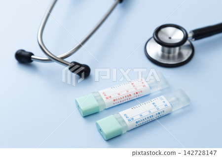 A stool sample kit and stethoscope on a blue background. A stool sample kit and stethoscope on a blue background. 142728147