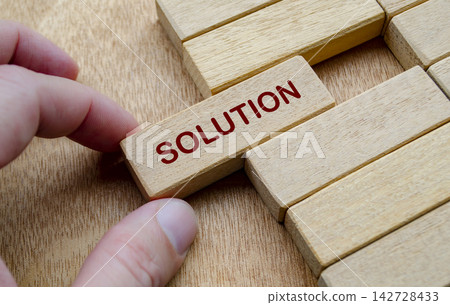Wooden blocks and hand representing finding solutions through active problem solving and critical thinking 142728433