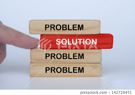Hand moving a solution block toward wooden pieces representing progress and overcoming challenges Hand moving a solution block toward wooden pieces representing progress and overcoming challenges 142728451