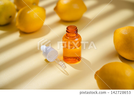 Vitamin C skincare serum in dropper bottle surrounded by fresh lemons on yellow background, bright natural beauty and antioxidant concept Vitamin C skincare serum in dropper bottle surrounded by fresh lemons on yellow background, bright natural beauty and antioxidant concept 142728653