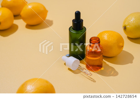 Vitamin C skincare serum in dropper bottles surrounded by fresh lemons on yellow background, bright natural beauty and antioxidant concept Vitamin C skincare serum in dropper bottles surrounded by fresh lemons on yellow background, bright natural beauty and antioxidant concept 142728654