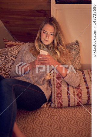 Girl, smartphone and texting with social media, browse and online entertainment with internet. Woman, bed and communication or video streaming for happiness, relaxation and bedroom with technology Girl, smartphone and texting with social media, browse and online entertainment with internet. Woman, bed and communication or video streaming for happiness, relaxation and bedroom with technology 142728680