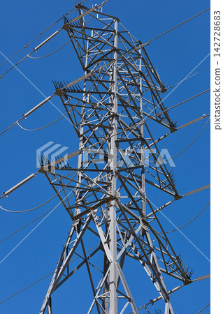Blue sky, cable and power with electricity pylon outdoor from below for generation or supply. Frame, metal or steel and infrastructure with transfer of high voltage current on grid for consumption Blue sky, cable and power with electricity pylon outdoor from below for generation or supply. Frame, metal or steel and infrastructure with transfer of high voltage current on grid for consumption 142728683
