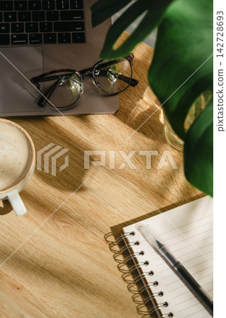Home office workspace with open notebook, coffee and eyeglasses on wooden desk, top view with copy space Home office workspace with open notebook, coffee and eyeglasses on wooden desk, top view with copy space 142728693