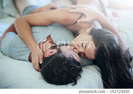 Passion, love and couple in bed with kiss, romance and morning bonding in apartment. Relationship, man and woman in bedroom with intimate embrace, affection and relax with care on weekend in home 142728895