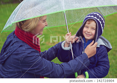 Mother, boy and rain for umbrella, smile and child with portrait for winter and safety of waterproof. Happiness, mom and adorable kid in park, parent and youth in weather of Austin and joy for water Mother, boy and rain for umbrella, smile and child with portrait for winter and safety of waterproof. Happiness, mom and adorable kid in park, parent and youth in weather of Austin and joy for water 142728904