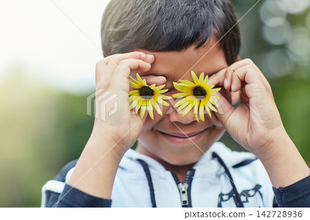 Boy, happy and flower eyes outdoor in nature for playing game, creativity and social development. Kid, smile and sunflower on face in summer at park for fantasy, storytelling and children adventure Boy, happy and flower eyes outdoor in nature for playing game, creativity and social development. Kid, smile and sunflower on face in summer at park for fantasy, storytelling and children adventure 142728936
