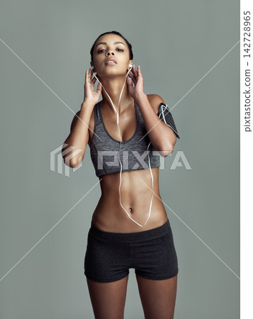 Fitness, portrait and woman with earphones in studio for streaming music, motivation podcast or workout playlist. Grey background, exercise and female athlete for cardio, running or physical training Fitness, portrait and woman with earphones in studio for streaming music, motivation podcast or workout playlist. Grey background, exercise and female athlete for cardio, running or physical training 142728965