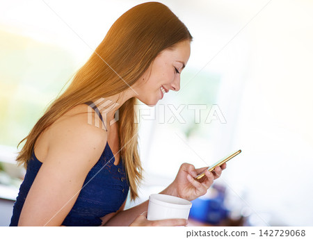 Kitchen, girl and smartphone in morning with coffee to relax, chat and social media at home. House, woman and cellphone for text message, online meme or comedy and connection with technology by space Kitchen, girl and smartphone in morning with coffee to relax, chat and social media at home. House, woman and cellphone for text message, online meme or comedy and connection with technology by space 142729068