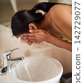 Woman, face and washing with water in home bathroom for skincare routine, skin cleaning and personal hygiene. Girl, splash and wet hands for wellness, health and self care or beauty in house by tap 142729077