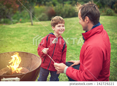 Father, outdoors and son with marshmallow for roasting on flame with bonding for happiness. Child development, smile and camping with scenic campsite in winter morning on weekend away to Germany. Father, outdoors and son with marshmallow for roasting on flame with bonding for happiness. Child development, smile and camping with scenic campsite in winter morning on weekend away to Germany. 142729221