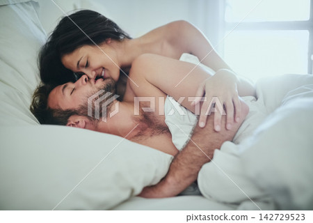 Love, morning and couple in bed with kiss, romance and happy bonding in apartment. Relationship, man and woman relax in bedroom with intimate embrace, passion and wake up with care on weekend in home Love, morning and couple in bed with kiss, romance and happy bonding in apartment. Relationship, man and woman relax in bedroom with intimate embrace, passion and wake up with care on weekend in home 142729523