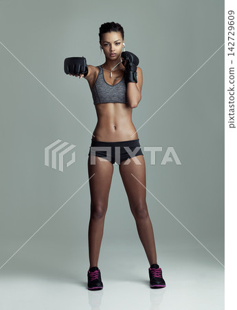 Boxing, exercise and music with portrait of woman in studio isolated on gray background. Fitness, strike and workout with serious boxer athlete training at gym for challenge, health or performance Boxing, exercise and music with portrait of woman in studio isolated on gray background. Fitness, strike and workout with serious boxer athlete training at gym for challenge, health or performance 142729609