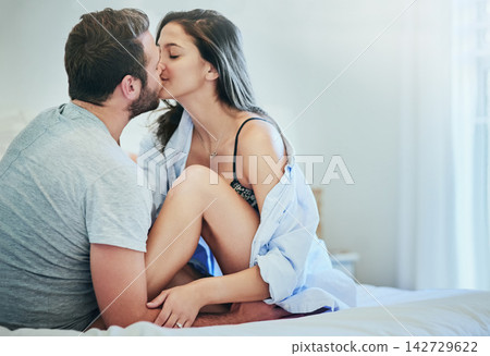 Love, affection and couple in bed with kiss, romance and and morning bonding in apartment. Relationship, man and woman in bedroom with intimate embrace, passion and relax with care on weekend in home Love, affection and couple in bed with kiss, romance and and morning bonding in apartment. Relationship, man and woman in bedroom with intimate embrace, passion and relax with care on weekend in home 142729622