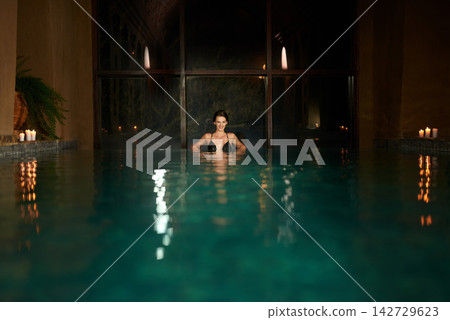 Dark, pool and relax for woman in resort, calm and hotel or accommodation for holiday or vacation travel. Luxury, water and freedom for wellness and night for female person, spa and salon treatment Dark, pool and relax for woman in resort, calm and hotel or accommodation for holiday or vacation travel. Luxury, water and freedom for wellness and night for female person, spa and salon treatment 142729623