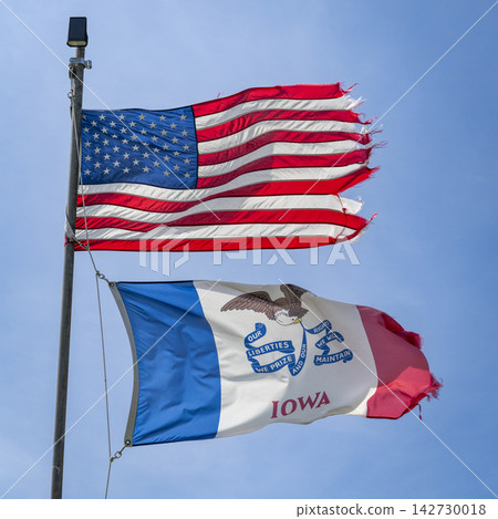 American and State of Iowa flags proudly waving and fluttering on a strong wind American and State of Iowa flags proudly waving and fluttering on a strong wind 142730018