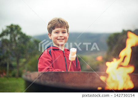 Fire, outdoors and boy in portrait with marshmallow for cooking on flame with happiness. Child development, camping and smile with scenic mountain in winter morning at campsite in Switzerland. Fire, outdoors and boy in portrait with marshmallow for cooking on flame with happiness. Child development, camping and smile with scenic mountain in winter morning at campsite in Switzerland. 142730154
