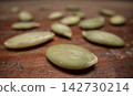 pile of pumpkin seeds on a weathered wood, macro shot with a probe lens 142730214