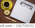 blank spiral notebook with grid paper, flat lay with coffee and reading glasses on textured art paper 142730222