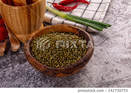 Mung beans in wooden bowl, surrounded by fresh garlic, red chili, green onion, cooking ingredients Mung beans in wooden bowl, surrounded by fresh garlic, red chili, green onion, cooking ingredients 142730755