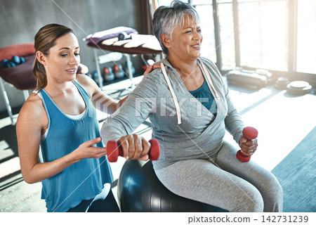 Old woman, physiotherapy and dumbbell exercise or arm rehabilitation for injury training, joint pain or inflammation. Senior person, arthritis and muscle mobility on fitness ball, recovery or workout Old woman, physiotherapy and dumbbell exercise or arm rehabilitation for injury training, joint pain or inflammation. Senior person, arthritis and muscle mobility on fitness ball, recovery or workout 142731239