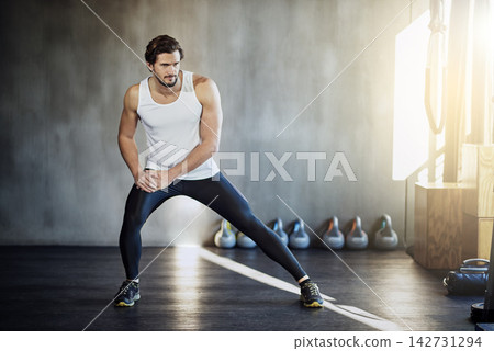 Man, gym and legs stretching for exercise warm up for athlete mobility or self care routine, workout or fitness. Male person, training and sports centre for physical activity, athletic or wellness 142731294