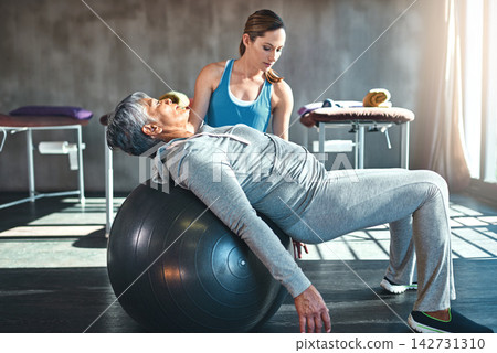 Workout, physiotherapist and senior woman with ball in clinic for physiotherapy, support or stretching. Wellness, female coach and elderly patient for balance, recovery training or rehabilitation Workout, physiotherapist and senior woman with ball in clinic for physiotherapy, support or stretching. Wellness, female coach and elderly patient for balance, recovery training or rehabilitation 142731310