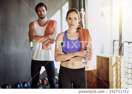 Crossed arms, exercise and portrait of couple in gym for intense training, fitness and cardio workout. Sports, personal trainer and man and woman for wellness, healthy body and performance with water Crossed arms, exercise and portrait of couple in gym for intense training, fitness and cardio workout. Sports, personal trainer and man and woman for wellness, healthy body and performance with water 142731352