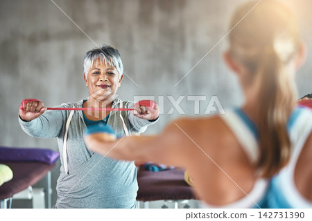Personal trainer, fitness and mature woman with band for training, exercise and cardio workout. Sports coach, retirement and women for wellness, health and wellbeing with stretching equipment in gym Personal trainer, fitness and mature woman with band for training, exercise and cardio workout. Sports coach, retirement and women for wellness, health and wellbeing with stretching equipment in gym 142731390