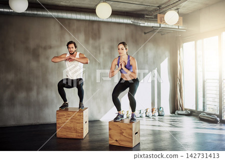 Jump, exercise and couple in gym with box, power and training at workout challenge together. Man, woman and personal trainer with balance, muscle development and healthy body fitness at sports club Jump, exercise and couple in gym with box, power and training at workout challenge together. Man, woman and personal trainer with balance, muscle development and healthy body fitness at sports club 142731413