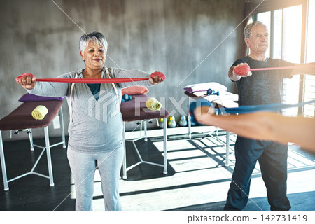 Stretching band, physiotherapy and senior people for support and help with muscle fitness by physiotherapist. Exercise, workout and strength training of mature clients in class for physical therapy Stretching band, physiotherapy and senior people for support and help with muscle fitness by physiotherapist. Exercise, workout and strength training of mature clients in class for physical therapy 142731419