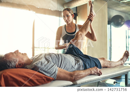Physiotherapy, old man and knee pain for recovery help or inflammation treatment, mobility or flexibility. Woman, check up and rehabilitation consultation with legs examination, accident or injury 142731756