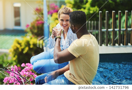 Couple, poolside and drinking or cheers in outdoor, bonding and together for love or talking. People, toast and speaking on holiday or vacation, alcohol and trees or celebration for peace and calm Couple, poolside and drinking or cheers in outdoor, bonding and together for love or talking. People, toast and speaking on holiday or vacation, alcohol and trees or celebration for peace and calm 142731796