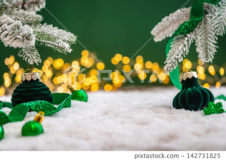 Emerald Christmas Ornaments Under Frosted Pine Branch on Snow Emerald Christmas Ornaments Under Frosted Pine Branch on Snow 142731825