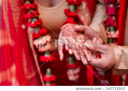 Hand, ring and henna tattoo as hindu woman for marriage, celebration or wedding with culture. Person, closeup and mehndi with jewelry, traditional clothes and bride for faith, good luck or prosperity Hand, ring and henna tattoo as hindu woman for marriage, celebration or wedding with culture. Person, closeup and mehndi with jewelry, traditional clothes and bride for faith, good luck or prosperity 142731932