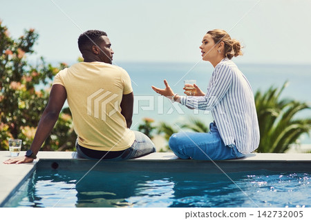 Couple, talking and drinking by pool on holiday with bonding, relax and summer vacation at accommodation. Interracial, people and alcohol with poolside at hotel for discussion or healthy relationship Couple, talking and drinking by pool on holiday with bonding, relax and summer vacation at accommodation. Interracial, people and alcohol with poolside at hotel for discussion or healthy relationship 142732005