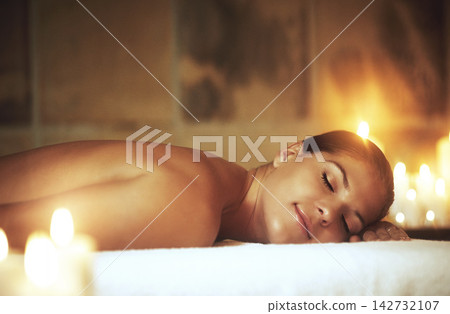 Woman, relax and spa treatment on massage bed for glow, wellness and cosmetics with candles. Zen, beauty and sleeping with peace after aromatherapy, deep tissue and stress relief with oil for luxury Woman, relax and spa treatment on massage bed for glow, wellness and cosmetics with candles. Zen, beauty and sleeping with peace after aromatherapy, deep tissue and stress relief with oil for luxury 142732107