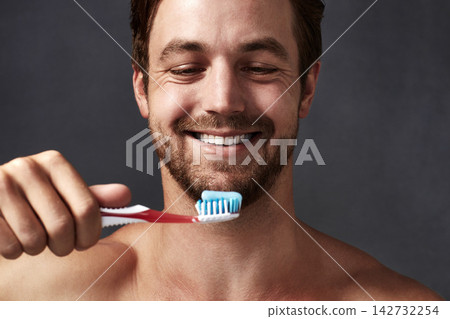 Face, oral hygiene and toothbrush with man in studio isolated on blue background for dental care. Brushing teeth, product and toothpaste with person in bathroom, cleaning mouth for protection Face, oral hygiene and toothbrush with man in studio isolated on blue background for dental care. Brushing teeth, product and toothpaste with person in bathroom, cleaning mouth for protection 142732254