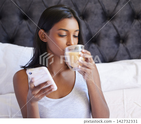 Woman, coffee in bed and smartphone for morning routine, caffeine for energy and warm beverage with social media. Scroll, drink and network for internet, mobile app and using phone in bedroom at home Woman, coffee in bed and smartphone for morning routine, caffeine for energy and warm beverage with social media. Scroll, drink and network for internet, mobile app and using phone in bedroom at home 142732331