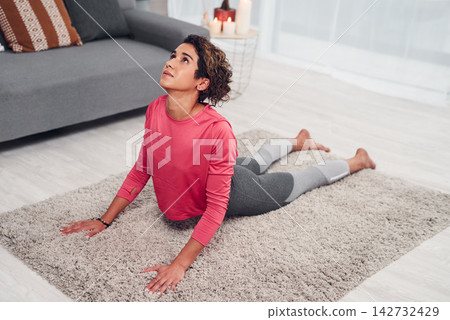 Yoga, balance and woman in living room at apartment for body fitness, self care or exercise. Wellness, stretching and female person with pilates workout on carpet in lounge at home for mindfulness. Yoga, balance and woman in living room at apartment for body fitness, self care or exercise. Wellness, stretching and female person with pilates workout on carpet in lounge at home for mindfulness. 142732429