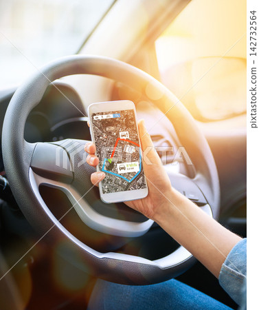 Person, hand and map on smartphone in car for driving service with navigation app for direction for pickup in city. Mobile, vehicle and driver online for geolocation, digital route and auto tracking. Person, hand and map on smartphone in car for driving service with navigation app for direction for pickup in city. Mobile, vehicle and driver online for geolocation, digital route and auto tracking. 142732564