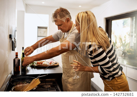 Mature, couple and cooking dinner in kitchen with wine drinking for marriage bonding, vegetables or home. Man, woman and nutrition supper for anniversary meal or alcohol, together or relationship Mature, couple and cooking dinner in kitchen with wine drinking for marriage bonding, vegetables or home. Man, woman and nutrition supper for anniversary meal or alcohol, together or relationship 142732681