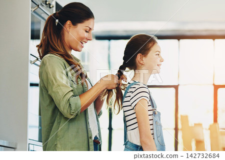 Braiding, child and mom with routine, laughing and grooming with smile, home and woman with daughter. Family, mother and hairstyle change for girl in kitchen, bonding and hair maintenance with skills Braiding, child and mom with routine, laughing and grooming with smile, home and woman with daughter. Family, mother and hairstyle change for girl in kitchen, bonding and hair maintenance with skills 142732684
