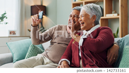 Senior couple, laugh and smartphone for video call, contact and communication in living room. People, mature man and woman on sofa, couch and house together with cellphone for online conversation Senior couple, laugh and smartphone for video call, contact and communication in living room. People, mature man and woman on sofa, couch and house together with cellphone for online conversation 142733161