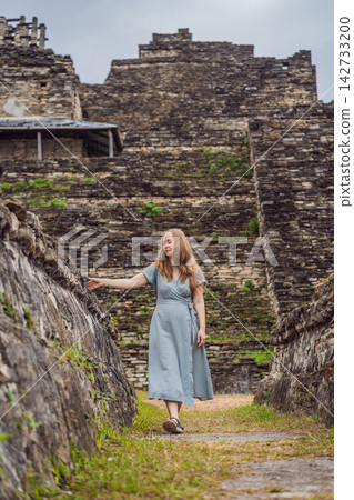 Woman traveler walking among ancient stone terraces at Tonina Maya ruins in Chiapas Mexico with pre Hispanic history stone walls cultural heritage Mexican archaeology and looking at camera. Woman traveler walking among ancient stone terraces at Tonina Maya ruins in Chiapas Mexico with pre Hispanic history stone walls cultural heritage Mexican archaeology and looking at camera. 142733200