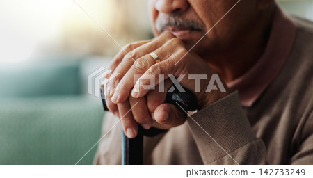 Old man, hands and walking stick in home for retirement grief for remember nostalgia, memory or thoughts. Male person, cane and wedding ring for elderly widower or unhappy, contemplating or lonely Old man, hands and walking stick in home for retirement grief for remember nostalgia, memory or thoughts. Male person, cane and wedding ring for elderly widower or unhappy, contemplating or lonely 142733249
